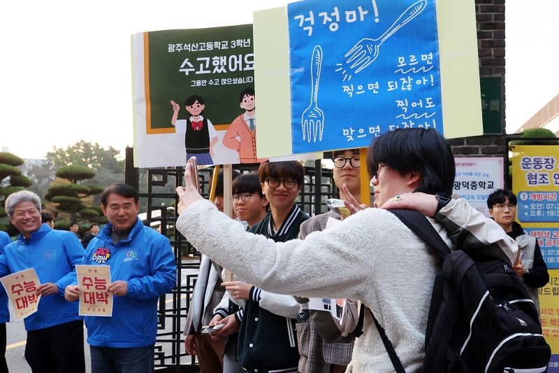  Underclassmen and others on Nov. 14 cheer for upperclassmen entering Kwangdeok High School in Gwangju's Seo-gu District to take the annual College Scholastic Ability Test. The Ministry of Education said the number of exam takers this year reached 522,670, up 18,082 from last year.